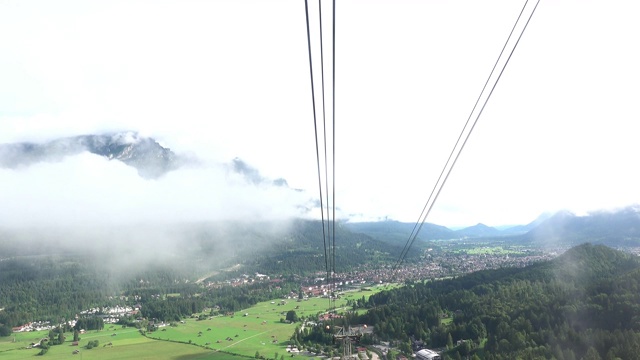 观看Garmisch-Partenkirchen，乘坐缆车进入云层和云层之上。视频素材