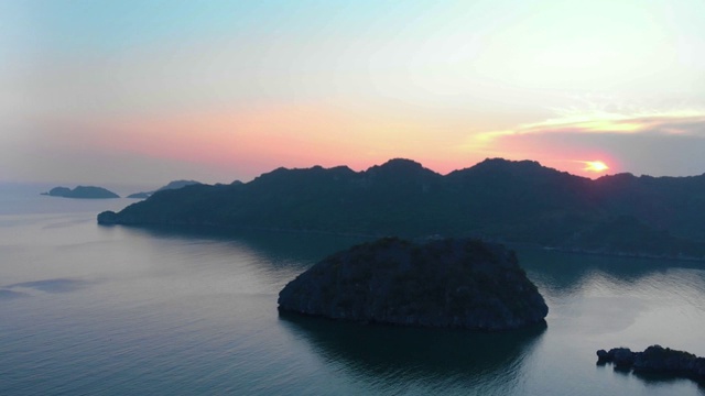 空中:日落时分，飞越吉巴岛和下龙湾岩石尖塔，这是越南著名的旅游目的地视频素材