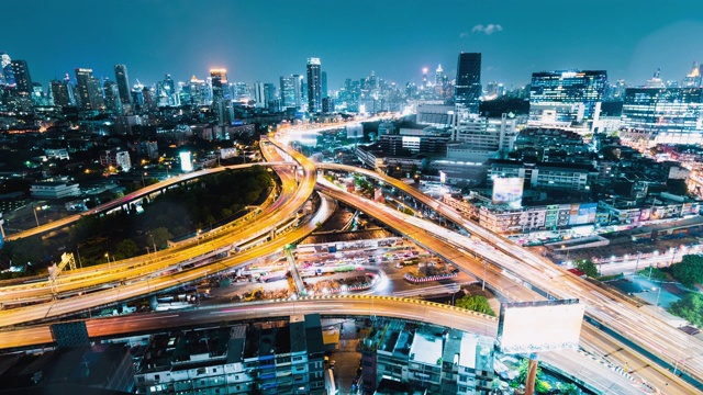 在泰国曼谷市的高速公路十字路口的汽车交通延时，在晚上下着雨。公共交通，通勤生活方式，亚洲城市生活理念。高角度视图视频素材