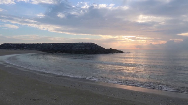 彩色柔和的日出天空时间流逝在平静的海水表面反射的太阳光线视频素材