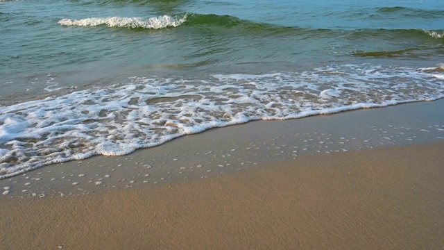 沙滩上一波又一波的蓝色海浪，4K视频显示海浪从上方撞击空旷的海滩。视频素材