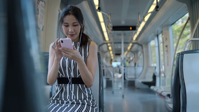 年轻女子在乘坐地铁上下班时使用手机视频素材