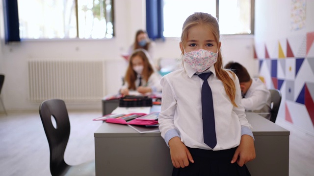 可爱的小学小女孩戴着面具摆姿势视频素材