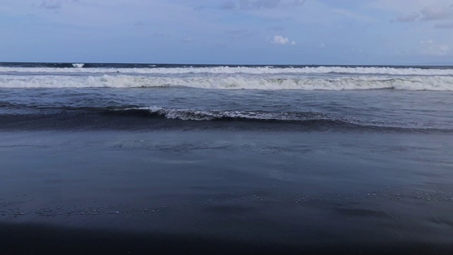 海洋/海岸上的黑砂火山海滩。视频素材