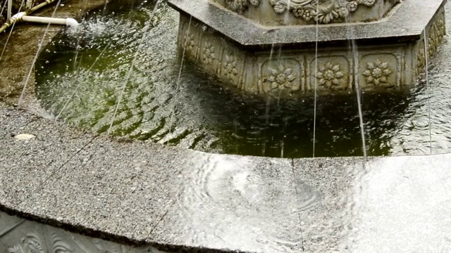 喷涌的水在喷泉中流动。夏天，水滴落在室外的大理石瓷砖上视频素材