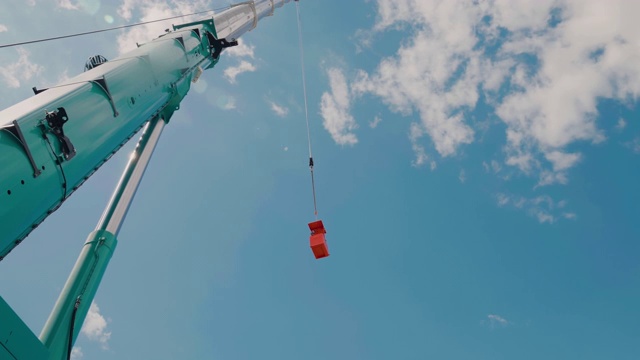 一个橙色的建筑摇篮由移动起重机吊起视频素材