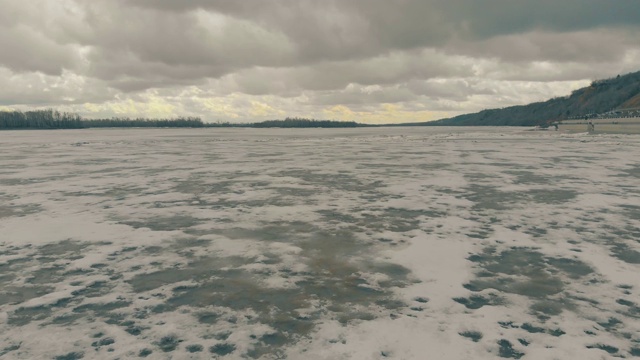 在河水表面的褐色脏雪和冰之上的运动视频素材