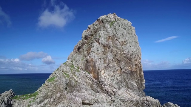 在一个美丽的热带岛屿上，环绕着一块突出的岩石飞行视频素材