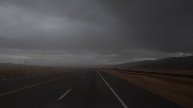 汽车在雨中行驶在美国犹他州摩押的一条偏僻的道路上视频素材