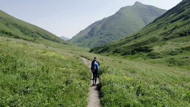 一对年轻的旅行者在山里徒步旅行视频素材