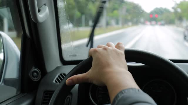 女人在下雨的时候握着方向盘开车视频素材