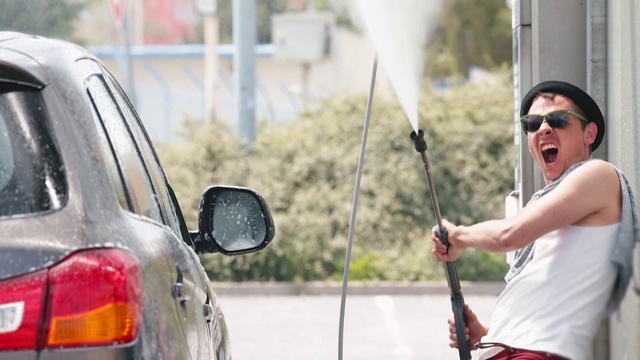 积极男子用水压洗车，高压。视频素材