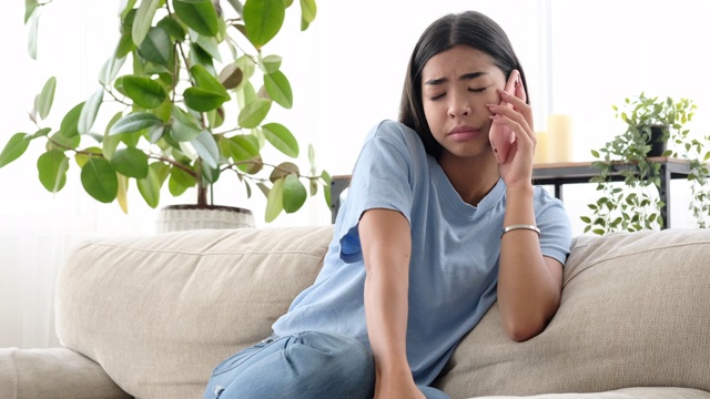 一个抑郁的女人在家里用手机聊天视频素材