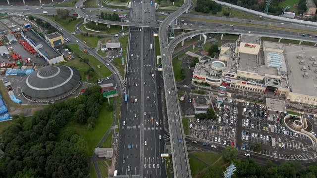 日落时分俯瞰莫斯科多层次交通交汇处上空的航班。城市高速公路上的汽车交通。无人机拍摄的城市景观视频素材