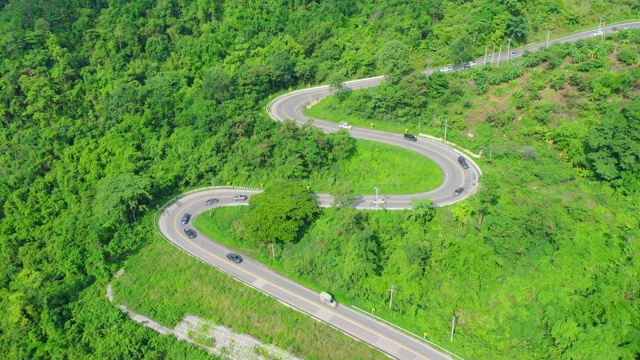 泰国绿树成荫的森林之间美丽的公路鸟瞰图。汽车在路上行驶。视频素材