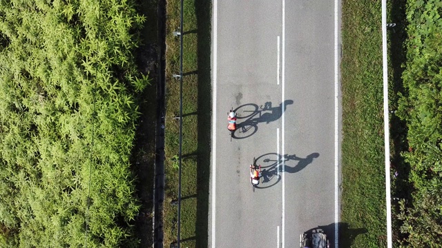 在乌鲁兰加农村地区骑自行车公路旅行与2名女运动员在早上无人机的观点视频素材