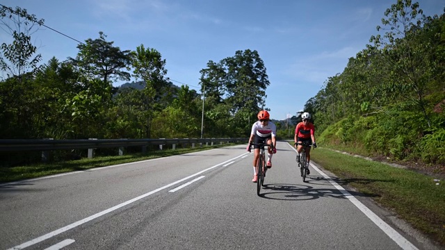 在乌鲁兰加农村地区的自行车骑公路旅行与2名女运动员骑手在早上视频素材