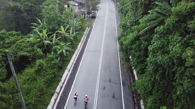 在乌鲁兰加农村地区骑自行车公路旅行与2名女运动员在早上无人机的观点视频素材