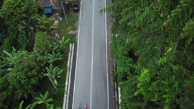 在乌鲁兰加农村地区骑自行车公路旅行与2名女运动员在早上无人机的观点视频素材