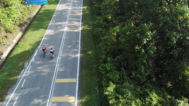 在乌鲁兰加农村地区骑自行车公路旅行与2名女运动员在早上无人机的观点视频素材