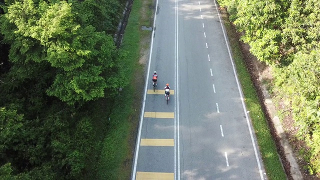 在乌鲁兰加农村地区骑自行车公路旅行与2名女运动员在早上无人机的观点视频素材