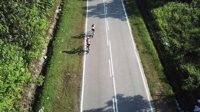 在乌鲁兰加农村地区骑自行车公路旅行与2名女运动员在早上无人机的观点视频素材