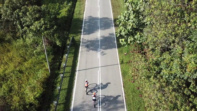 在乌鲁兰加农村地区骑自行车公路旅行与2名女运动员在早上无人机的观点视频素材