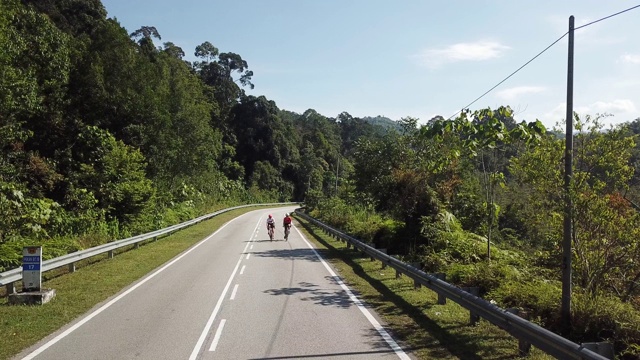 在乌鲁兰加农村地区骑自行车公路旅行与2名女运动员在早上无人机的观点视频素材