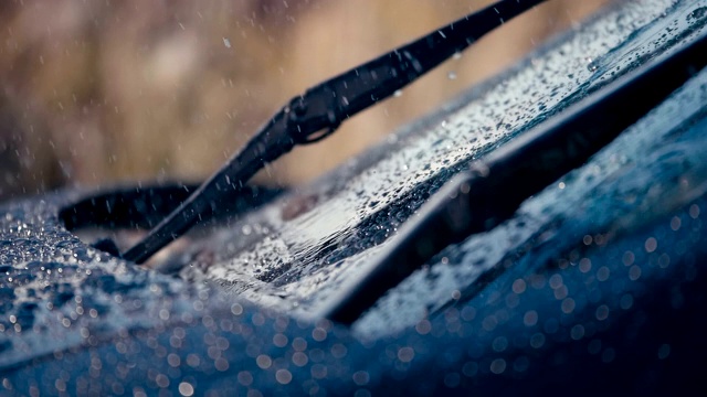 雨滴落在汽车的挡风玻璃上，刷子移动来清除水分视频素材