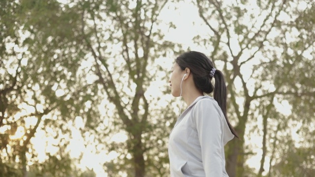 迷人的年轻亚洲女性跑步者在海边散步放松在海滩上跑步后。视频素材