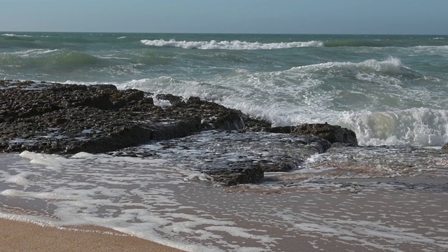 风平浪静的下午，沙滩上的波浪起伏视频素材