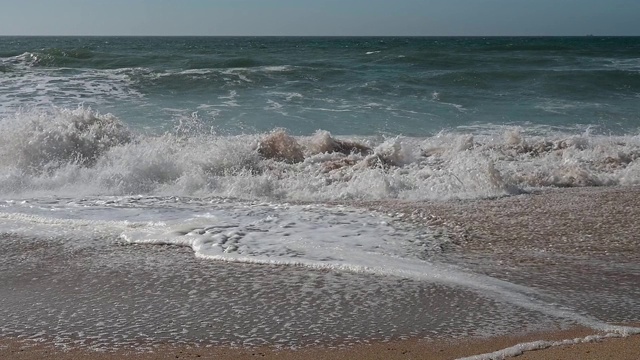 风平浪静的下午，沙滩上的波浪起伏视频素材