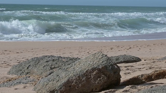 风平浪静的下午，沙滩上的波浪起伏视频素材