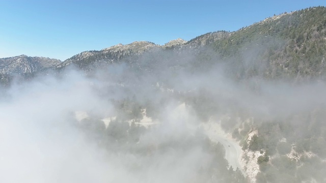 无人机摄像头拍摄的雾在道路附近的杂草丛生的山，美国加利福尼亚州视频素材