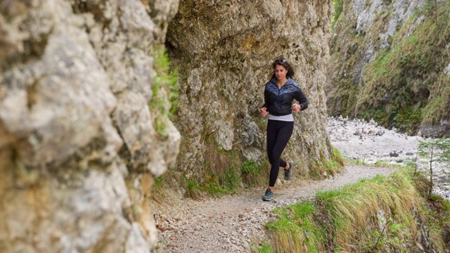 活跃的女人慢跑通过山涧山谷视频素材