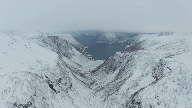 挪威Senja岛Medby附近积雪覆盖的山脉的航拍图。视频素材