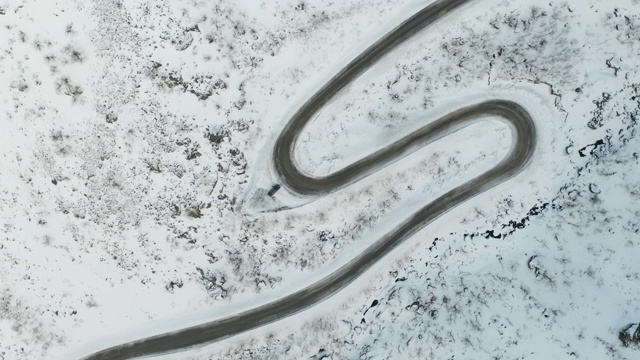 挪威Senja岛Medby附近积雪覆盖的山路的航拍图。视频素材