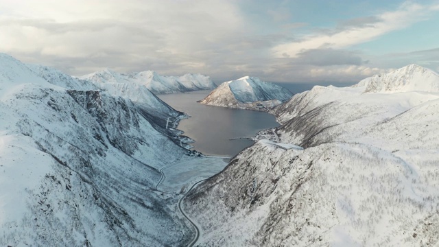 挪威Senja岛Medby附近积雪覆盖的山脉的航拍图。视频下载