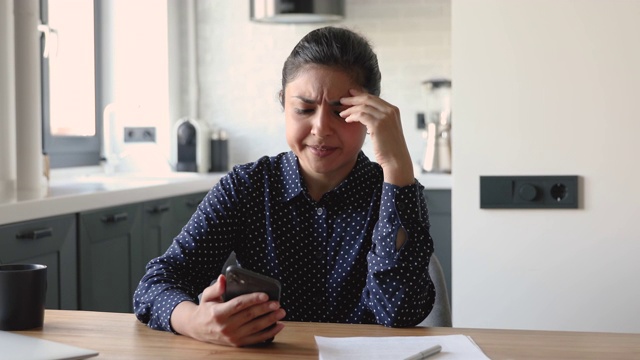 看手机短信的女人对可怕的消息感到沮丧视频素材