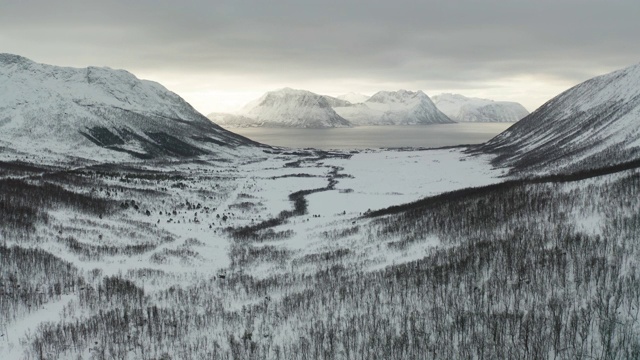 挪威Senja岛Stonglandseidet附近积雪覆盖的山脉的航拍图。视频素材