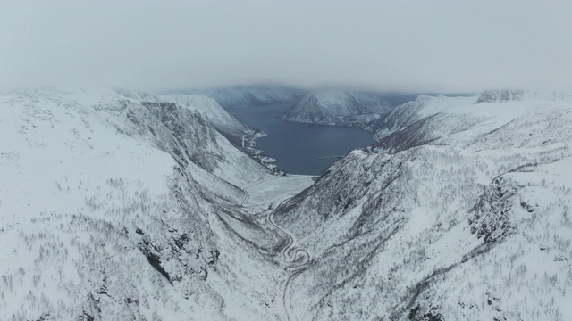 挪威Senja岛Medby附近积雪覆盖的山脉的航拍图。视频下载