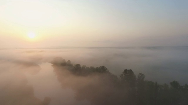 航拍美丽的自然环境与日出和清晨的雾。令人惊叹的风景朦胧的山谷在黎明。在美妙的乡村景色中飞过云层。慢动作视频素材