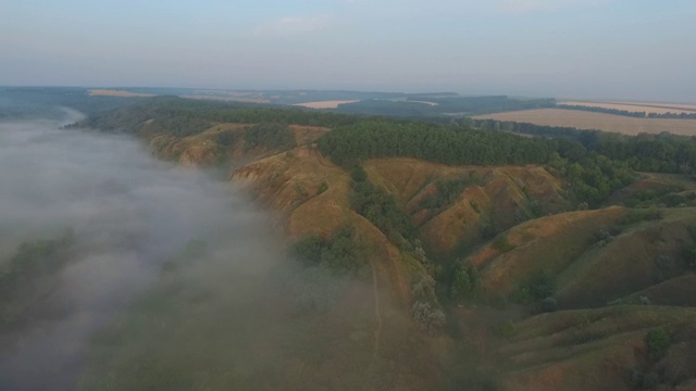 航拍清晨美丽的自然景观。山顶和山谷被浓雾覆盖，景色令人惊叹。飞行在美好的乡村环境。视频素材