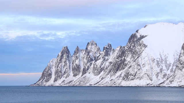 挪威北部Senja岛的Ersfjord附近的海岸线上覆盖着积雪的山脉。视频素材