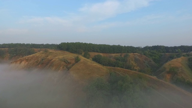 航拍清晨美丽的自然景观。山顶和山谷被浓雾覆盖，景色令人惊叹。飞行在美好的乡村环境。视频素材