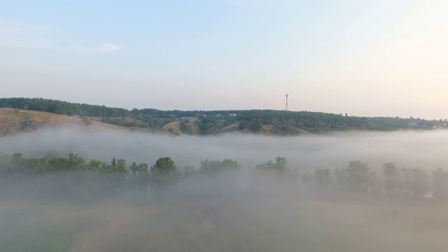 航拍清晨美丽的山景。雾气笼罩的山谷景色令人惊叹。飞行在美好的乡村环境。慢动作视频素材