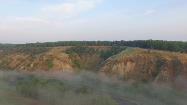 航拍清晨美丽的山景。雾气笼罩的山谷景色令人惊叹。飞行在美好的乡村环境。慢动作视频素材