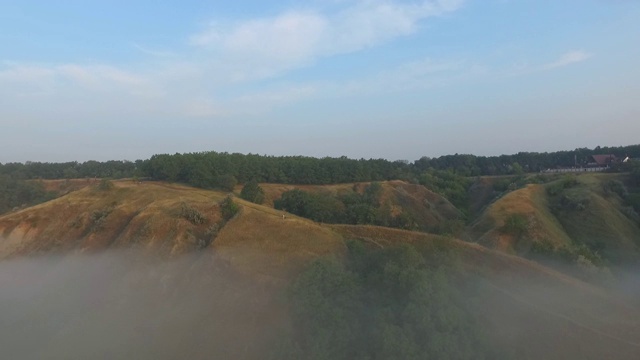 航拍清晨美丽的自然景观。山顶和山谷被浓雾覆盖，景色令人惊叹。飞行在美好的乡村环境。视频素材