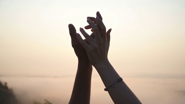 男性和女性的手牵着对方的剪影在日落的背景。一对年轻夫妇在户外并肩作战。爱和幸福的概念。情侣们享受着美丽浪漫的时刻。视频素材