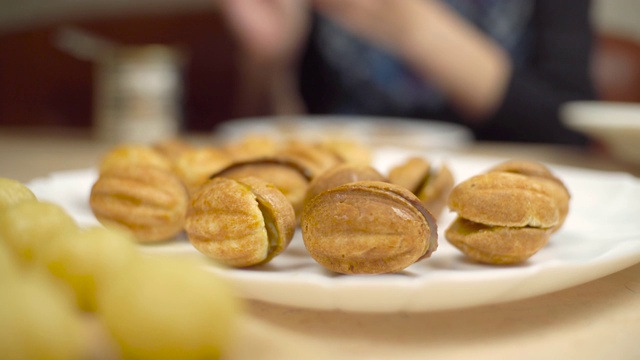 一个女人用炼乳做坚果甜点，自制蛋糕。视频素材